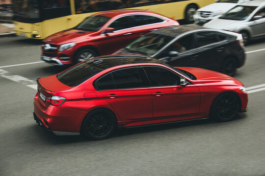 Kiev, Ukraine - June 12, 2021: Red matte BMW 328i car on the road. BMW in motion