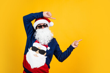 Fototapeta na wymiar santa claus bearded man in glasses wish happy new year and merry christmas holiday ready to celebrate winter party with fun and joy full of xmas presents and gifts, pointing finger