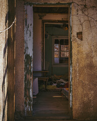 open door of an abandoned house showing trash on the floor
