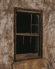 Obraz na płótnie Canvas Broken window of an abandoned stucco house 