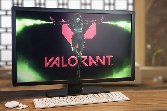 Valorant game on computer screen. Monitor, keyboard and airpods on wooden table. Selective focus. Rio de Janeiro, RJ, Brazil. December 2021