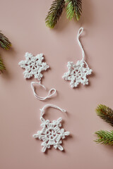 Sustainable and eco-friendly Christmas deco, handmade crochet cotton snowflakes, flatlay on beige - 474288297