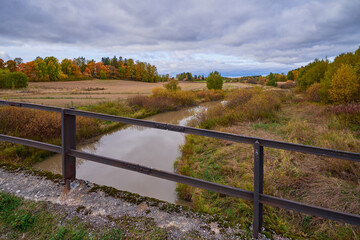 Golden autumn by the Kerava river in Finland: view from the old stone bridge.