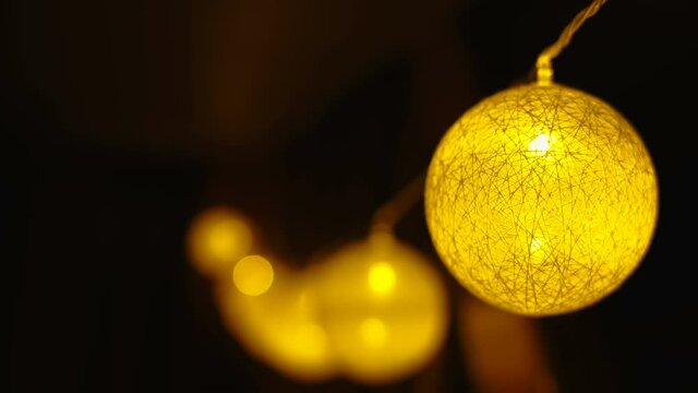 Closer look of the yellow Christmas ball hanging with the yellow lights inside in Tallinn in Estonia