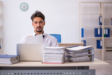 Young male employee and too much work in the office