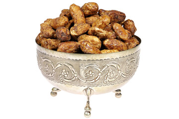 candied peanuts in a silver bowl isolated on white background