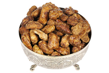candied peanuts in a silver bowl isolated on white background