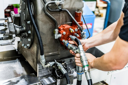 Industrial worker assembles agricultural equipment at plant