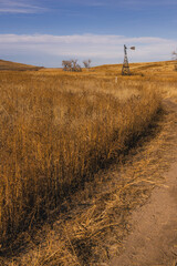 path leading to a windmill in the middle of a field