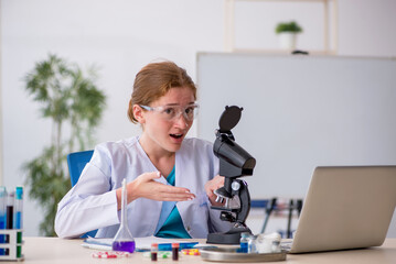 Young female chemist in drugs synthesis concept