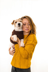A girl in a yellow jacket is holding a Jack Russell Terrier puppy. Isolate on white background