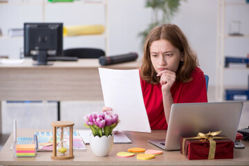 Young female designer celebrating Christmas in the office