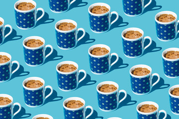 Sunlight pattern made with cups of coffee on blue background. Minimal  summer concept.