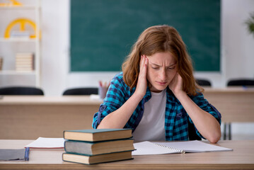 Young female student preparing for exam in the classroom