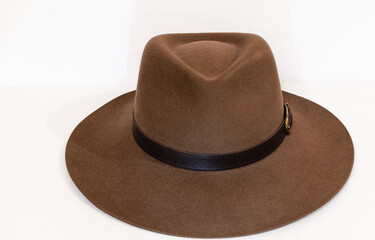 Classic cowboy brown felt hat with strap and copper closure on white background. Front view