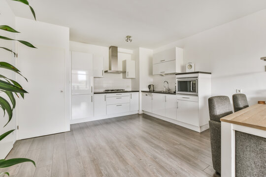 Modern kitchen with white kitchen unit and gray parquet floor