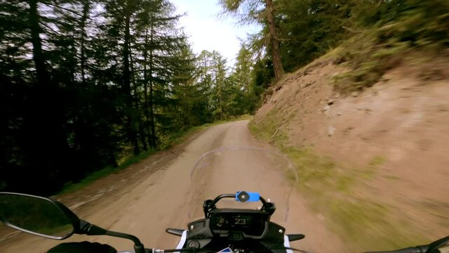A motorcycle ride on a small gravel mountain road, in the Swiss Alps on a sunny summer day
