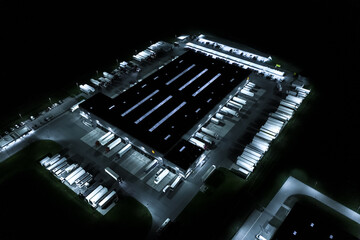 Aerial view of goods warehouse at Night. Logistics center in ind