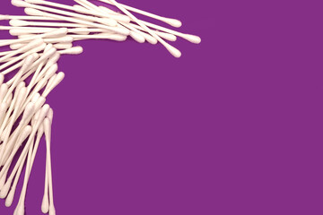 Obraz na płótnie Canvas isolated white cotton swabs - health care concept - purple background