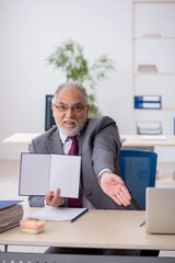 Old male employee sitting in the office