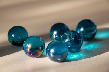 Blue marbles on melanin with natural lighting, children's play glass spheres.