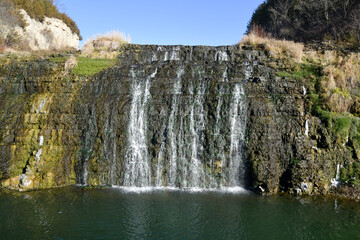 Fototapeta na wymiar Waterfall over the mossy rocks
