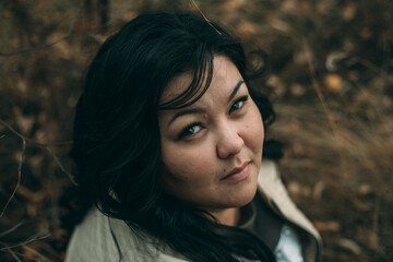 Beautiful plus size asian girl is resting in nature. autumn day