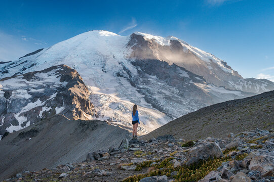 Female in blue shirt standing in front of Mount Rainier