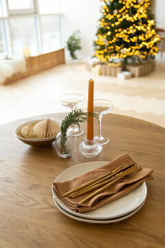 Served table in brown colors with a view of the Christmas tree