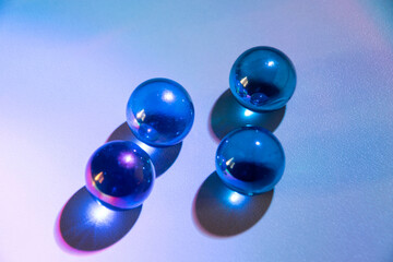 Blue marbles on melanin with natural lighting, children's play glass spheres.