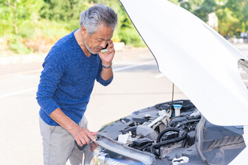 電話をするシニア男性　自動車　故障　困る