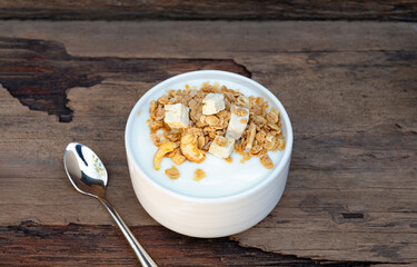 Yogurt greek white clean In bowl with spoon on a wooden background from top view.
