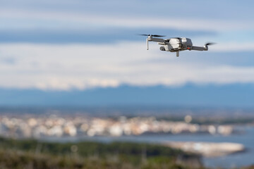 Drone flying near a coastal city with the background out of focus