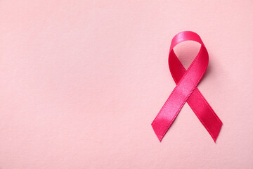 Pink ribbon on color background, top view with space for text. Breast cancer awareness concept