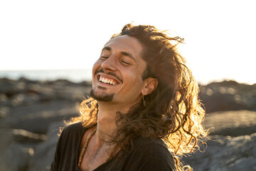Portrait of happy handsome hippie italian man with long hair smiling beautiful . Freedom. Wanderlust. Tropics. Traveler.Beach. Relax.