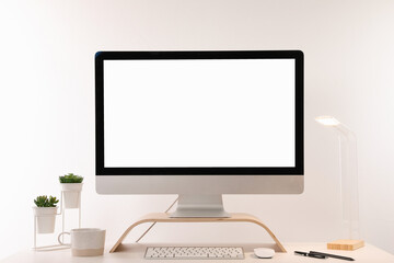 Comfortable workplace with blank computer display on desk against white background. Space for text
