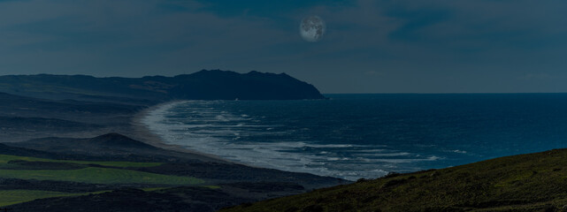 The moonlight shines on the coastline and creates a beautiful evening along the shore