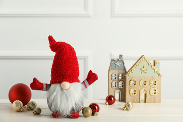 Cute Christmas gnome and festive decor on white wooden table