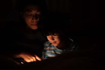 young Asian mother and little daughter girl on bed, cozy love sleepy at childhood home, at night