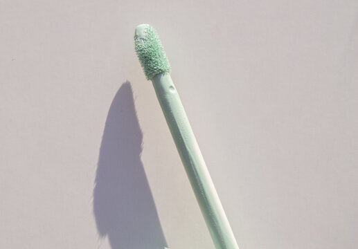 Close-up Of A Brush Of Green Concealer For Correcting Skin Imperfections, On A White Background