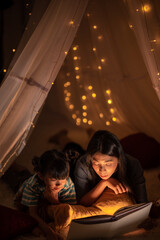 young Asian mother with little child daughter family happy in cozy night light at childhood home