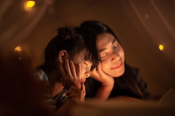 young Asian mother with little child daughter family happy in cozy night light at childhood home - obrazy, fototapety, plakaty