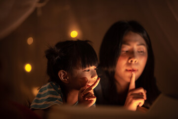 young Asian mother with little child daughter family happy in cozy night light at childhood home