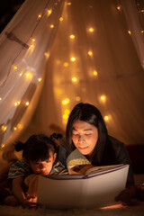 young Asian mother with little child daughter family happy in cozy night light at childhood home