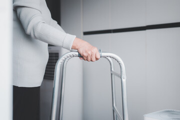 Eldrely woman hands holding walker trying to walk at home,Physical therapy concept