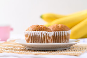 Homemade banana cupcake on plate and banana fruit on white background