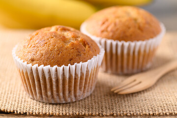 Homemade banana cupcake and banana fruit on brown background
