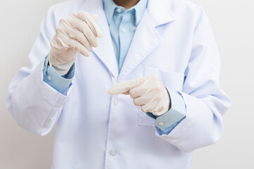 Medical personnel holding Antigen Test Kit (ATK) standing on white background.