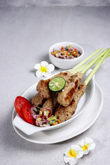 Sate Lilit, traditional Balinese minced seafood or chicken satay with lemongrass as aromatic skewer, served with sambal matah.