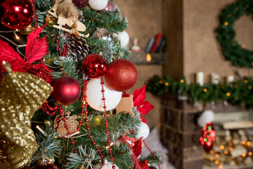 Closeup of red and white bauble hanging from a decorated Christmas branch. abstract background with defocused lights.Room decorated for the new year and Christmas.